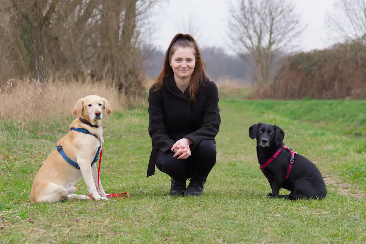 Michelle Marten - Dogwalker Dresden - schaut mit ihren Hunden Emma und Tyson auf einer Wiese in die Kamera
